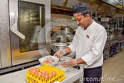 Professional chef cracking egg`s shells Editorial Stock Photo