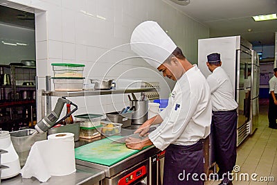 Professional chef cutting vegetables for salad at the kitchen of the restaurant Editorial Stock Photo