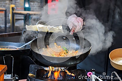 Professional chef and fire. Cooking vegetables and food Stock Photo