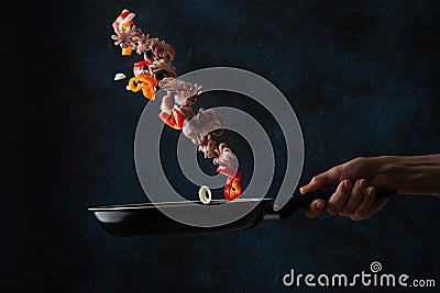 Professional chef fry octopus in a pan with pepper, freeze in motion, sea food Stock Photo