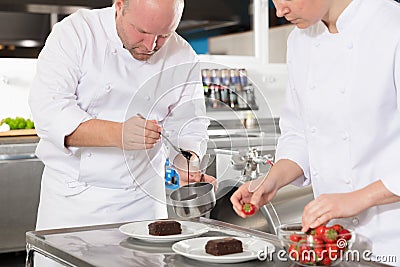 Professional chefs decorate dessert cake with lemon leaf Stock Photo