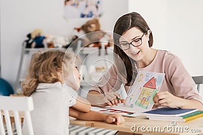 A professional child education therapist having a meeting with a kid in a family support center. Stock Photo