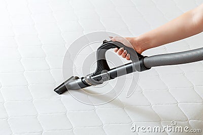 Professional cleaning mattress by vacuum cleaner from dust bacteria dirty. Female hand use vacuum cleaner machine for cleaning Stock Photo