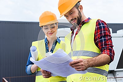 professional constructors in hardhats working with blueprints Stock Photo