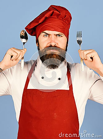 Professional cookery concept. Cook with serious face in burgundy uniform Stock Photo