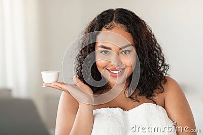 Professional cosmetics for beautiful skin. Black oversize woman holding jar with moisturising cream on open palm Stock Photo