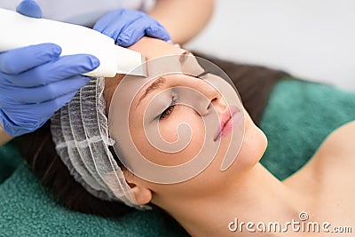 Professional cosmetologist is undergoing cavitation facial treatment Stock Photo