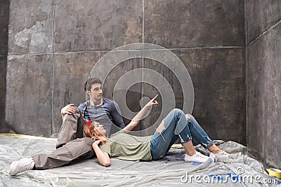 Professional couple sitting together on floor and discussing renovation home Stock Photo