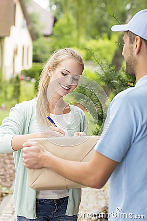 Courier with happy young customer signing a delivery form Stock Photo