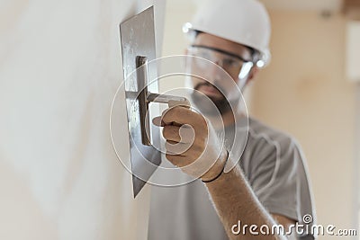 Professional craftsman applying plaster with a trowel Stock Photo