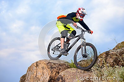 Professional Cyclist Riding the Bike on the Top of the Rock. Extreme Sport Concept. Space for Text. Stock Photo