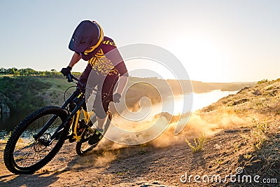 Cyclist Riding the Mountain Bike on the Summer Rocky Trail at the Evening. Extreme Sport and Enduro Cycling Concept. Stock Photo