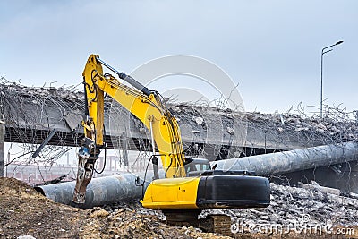 Professional demolition of reinforced concrete structures using industrial hydraulic hammer. Rods of metal fittings. Wreckage and Stock Photo