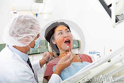 Dentist examines woman mouth at dental clinic Stock Photo
