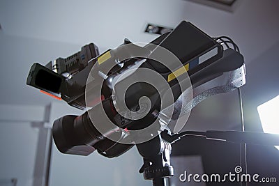 Professional digital Mirrorless camera with microphone on the tripod recording video .Side view of digital video camera Camcorder Stock Photo