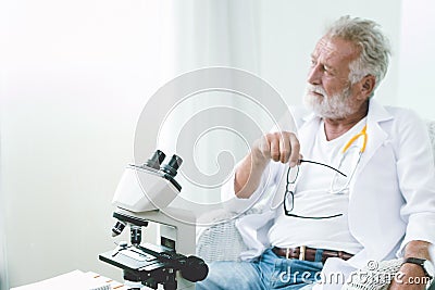 Professional doctor elderly thinking faraway look serious mood think of ways to cure the Corona virus and disease Stock Photo