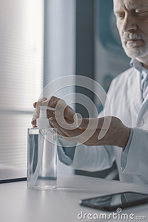 Doctor disinfecting his hands with sanitizer Stock Photo