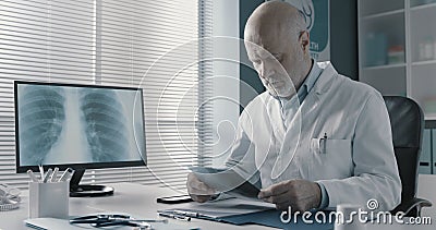 Professional doctor checking medical records in his office Stock Photo