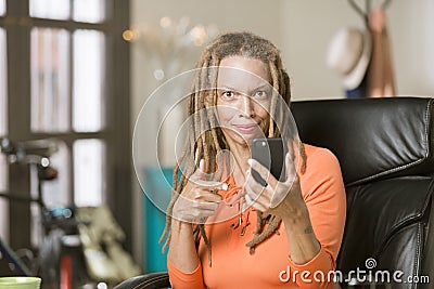 Busy Woman with Drealocks Pointing at Her Phone Stock Photo