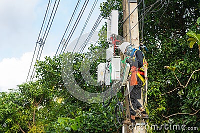 A professional electrician performs installation work on a pole. An electrician in professional equipment, working in dangerous Editorial Stock Photo