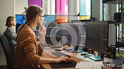 Professional Female Backend Software Developer Coding on Desktop Computer With Two Displays in Stock Photo