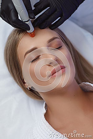 Professional female cosmetologist doing hydrafacial procedure in Cosmetology clinic. Stock Photo