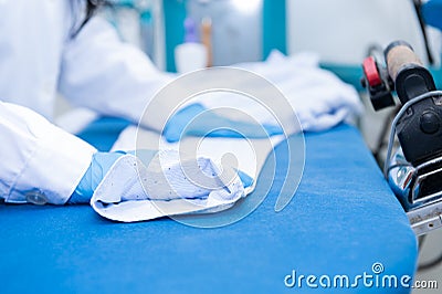 Professional female dry cleaner prepares a shirt for ironing Stock Photo