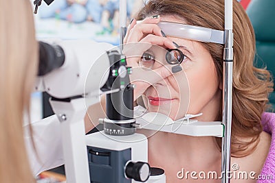 Professional female ophthalmologist is checking human eyes Stock Photo