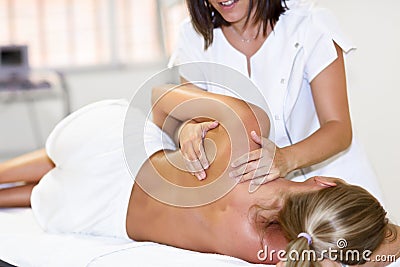 Professional female physiotherapist giving shoulder massage to b Stock Photo