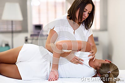 Professional female physiotherapist giving shoulder massage to b Stock Photo