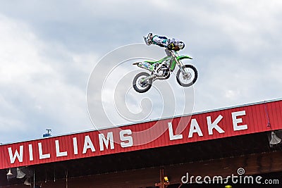 Professional freestyle motocross team member performs stunt high above audience Editorial Stock Photo