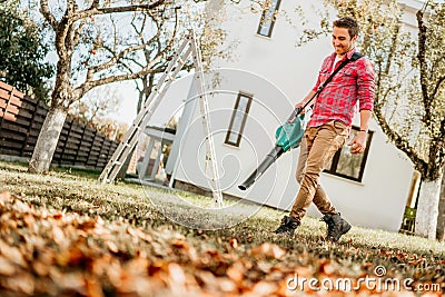 Professional gardener using leaf blower and working in garden Stock Photo