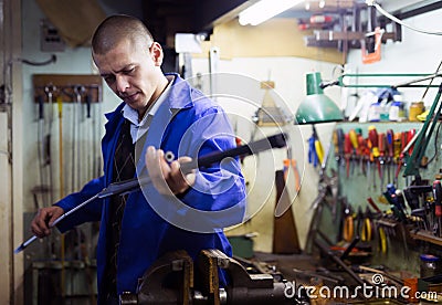 Gun repairman cleaning shotgun barrel before assembly in workshop Stock Photo