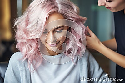 Professional hairdresser assisting girl with pink hair in hairstyling, with empty space for text Stock Photo