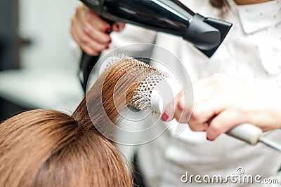 Professional hairdresser dries hair with hairdryer Stock Photo