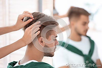 Professional hairdresser working with young man Stock Photo