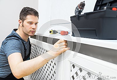 Professional handyman assembling radiator cabinet Stock Photo