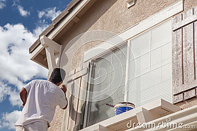 Professional House Painter Painting the Trim And Shutters of A H Stock Photo