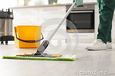 Professional janitor cleaning floor with mop in kitchen, closeup Stock Photo