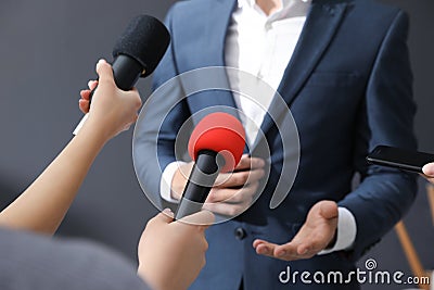 Professional journalists interviewing businessman on background, closeup Stock Photo