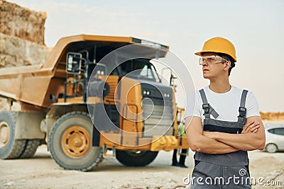 Professional loading vehicle. Worker in uniform is on the borrow pit at daytime Stock Photo