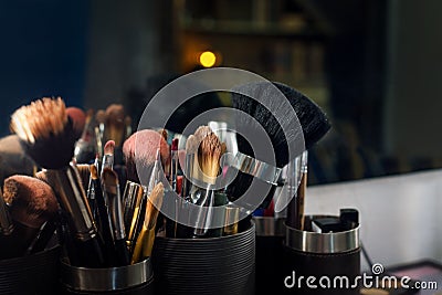 Professional makeup brushes set closeup near salon mirror.