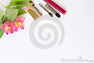 Professional makeup tools brushes, eye shadows, lipgloss, flowers flat lay composition copy space on white background Stock Photo