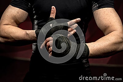 Professional male fighter preparing for training, wraping his hands and wrists Stock Photo