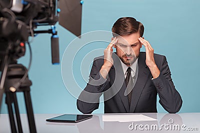 Professional male newscaster feels pain in his Stock Photo