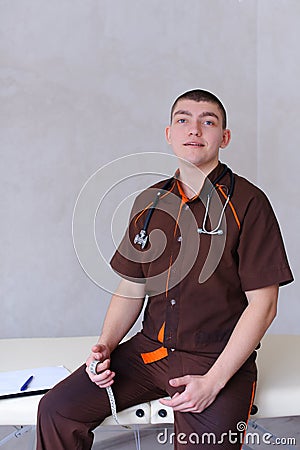 Professional male therapist looks at camera with smile and sitti Stock Photo