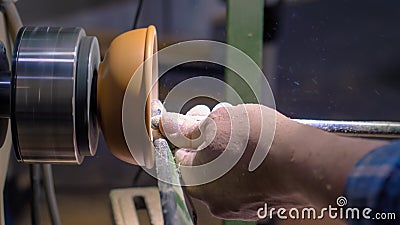 Carpenter using chisel for shaping wood piece on lathe - side view Stock Photo