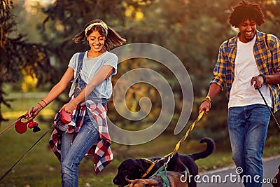 Professional man and woman dog walkers with dog enjoying in park Stock Photo