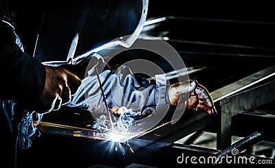Professional mask protected welder man working on metal welding. Selective Focus Stock Photo