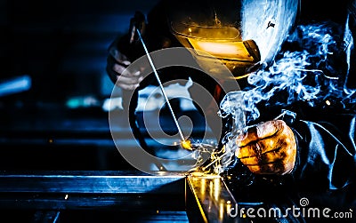 Professional mask protected welder man working on metal welding and sparks metal Stock Photo